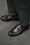 A close up of Velasca formal penny loafers in dark brown smooth leather.